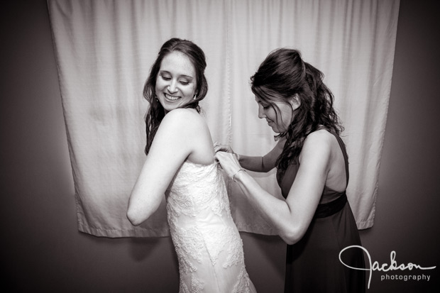 bridesmaid helping with bride's dress