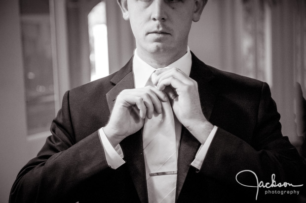 groom putting on his tie