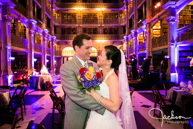 bride and groom at wedding reception lit by purple lights