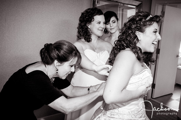 family tying bride's dress