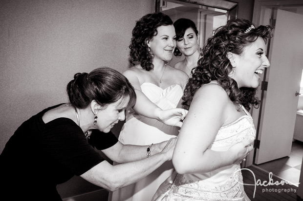 family tying bride's dress
