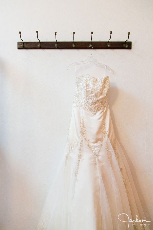 bride's dress hanging from wooden hook