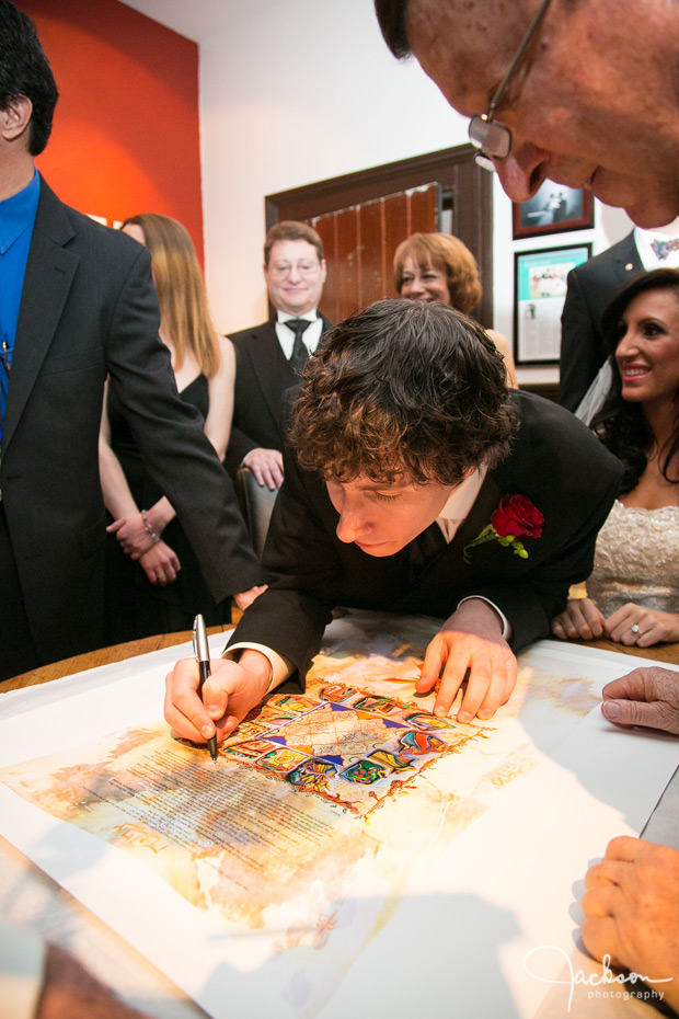 groom signing ketubah