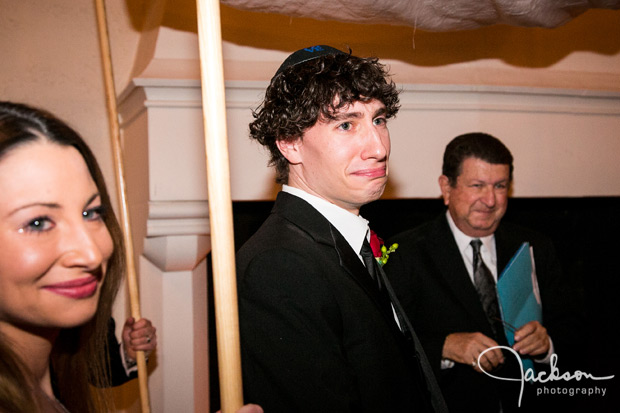 groom emotionally looking at bride walking down aisle