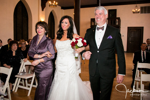 bride walking down aisle with mother and father