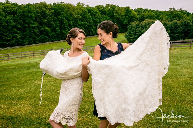 bride and sister holding dress