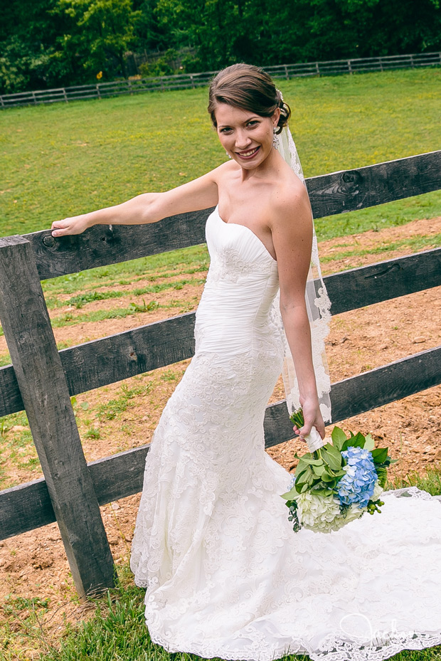 bride along wooden fence with blue green flowers